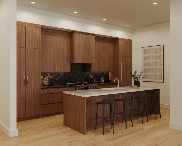 kitchen with wall chimney range hood, light hardwood / wood-style flooring, backsplash, a kitchen bar, and kitchen peninsula