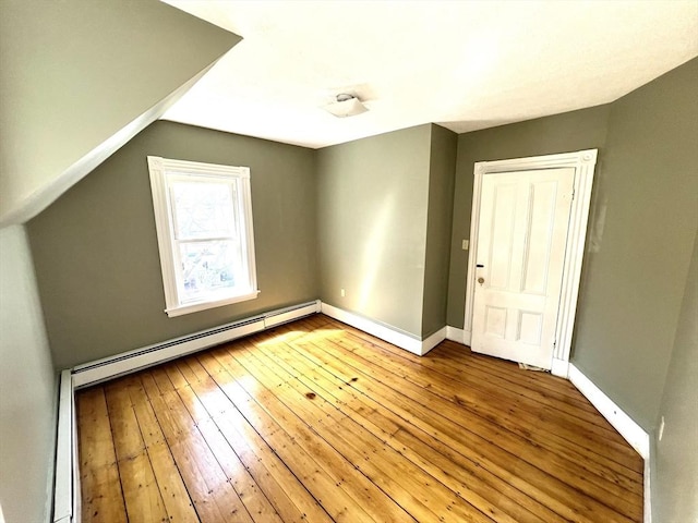bonus room featuring light wood-style floors, baseboards, and baseboard heating