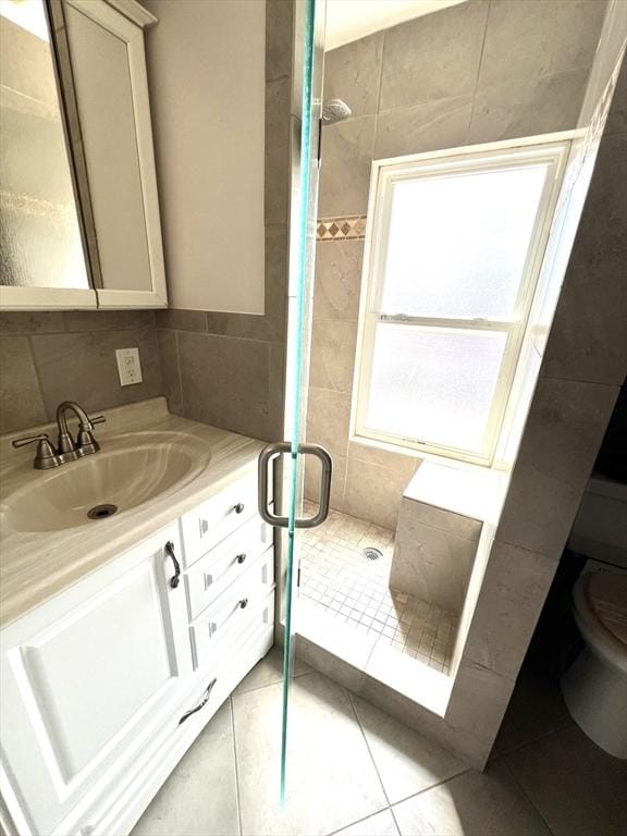 full bathroom featuring tile patterned floors, vanity, a shower stall, and toilet