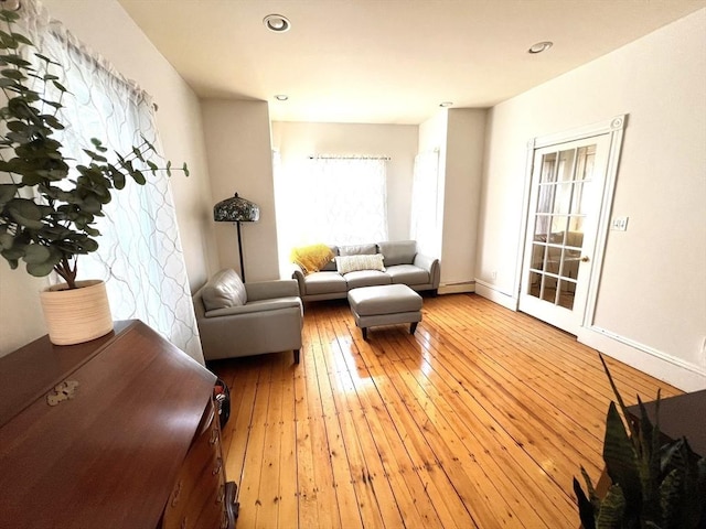 living room featuring a baseboard heating unit, hardwood / wood-style flooring, and recessed lighting