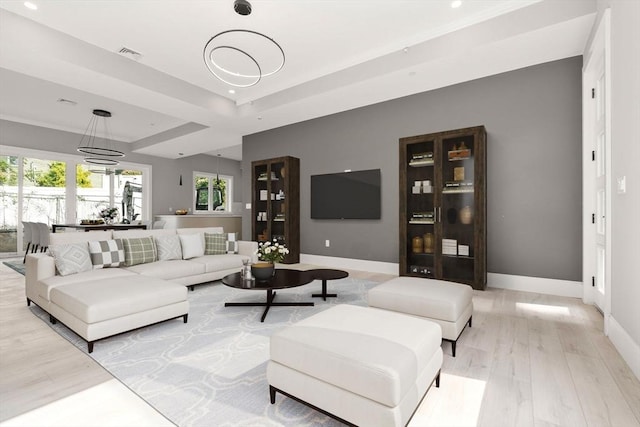 living area featuring recessed lighting, visible vents, baseboards, light wood-style floors, and a raised ceiling