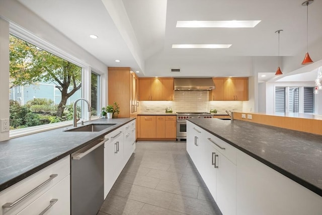 kitchen with white cabinetry, a skylight, stainless steel appliances, sink, and hanging light fixtures