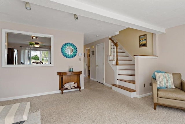 living area with baseboards, carpet, and stairs