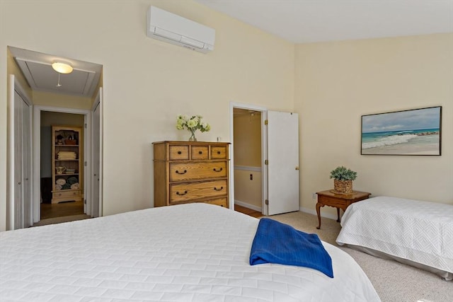 bedroom featuring baseboards, attic access, a high ceiling, a wall mounted AC, and carpet