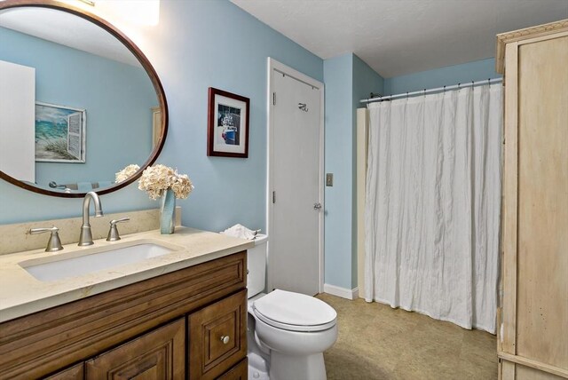 bathroom featuring vanity, a shower with shower curtain, tile patterned floors, and toilet