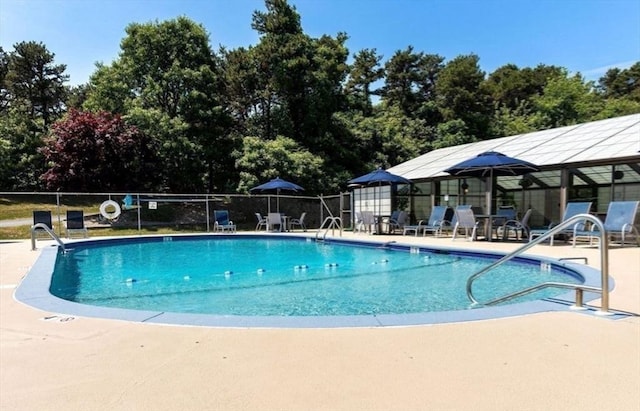 pool with a patio and fence