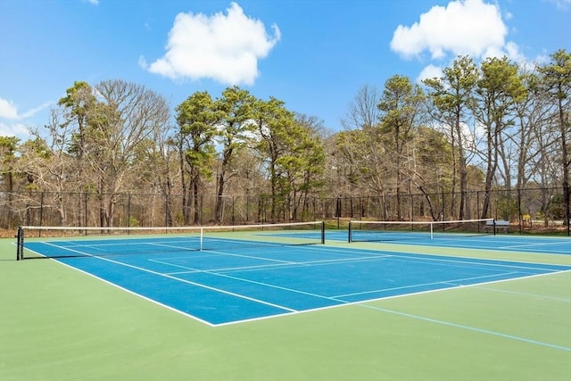 view of tennis court featuring fence and community basketball court