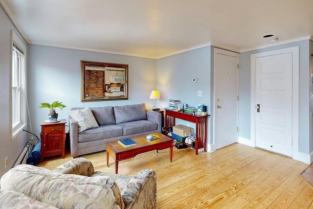 living room featuring light wood-style floors, baseboards, and crown molding