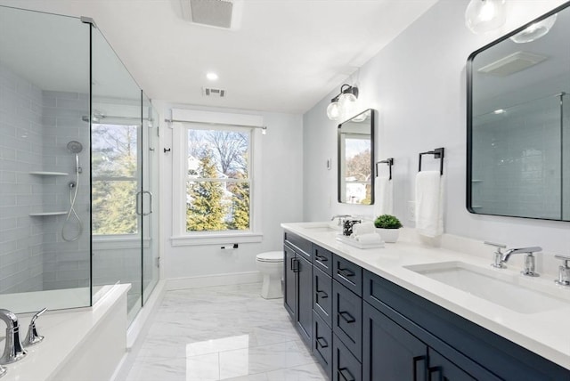 bathroom featuring vanity, toilet, a wealth of natural light, and a shower with shower door