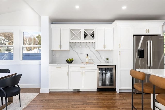 bar featuring white cabinets, high end fridge, dark wood-type flooring, and wine cooler