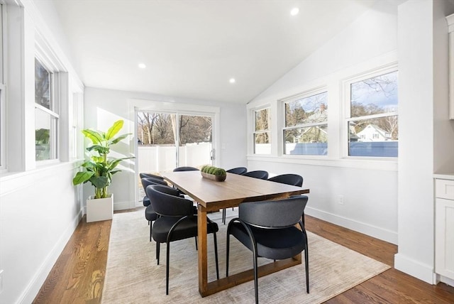 dining area with hardwood / wood-style flooring and vaulted ceiling