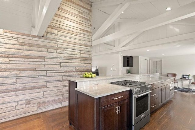 kitchen featuring stainless steel gas range oven, dark wood-type flooring, lofted ceiling with beams, open floor plan, and dark brown cabinets