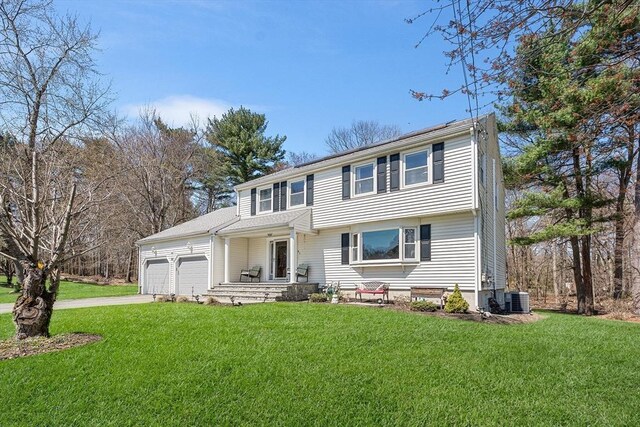 view of front facade featuring cooling unit, a garage, a front lawn, and concrete driveway