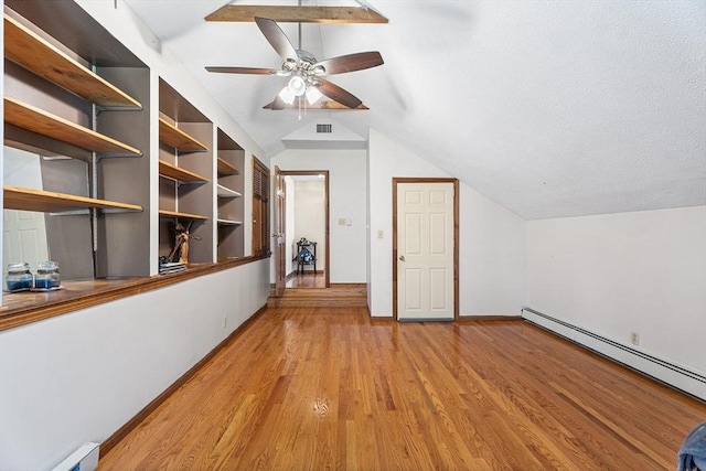 additional living space featuring lofted ceiling, baseboard heating, light wood-type flooring, ceiling fan, and baseboards