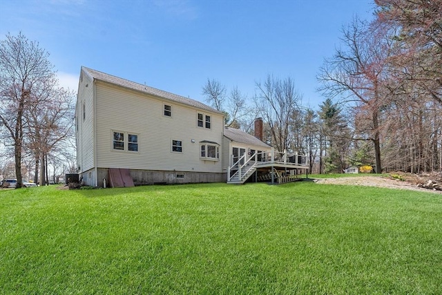 rear view of house with a wooden deck, stairs, a yard, and a chimney