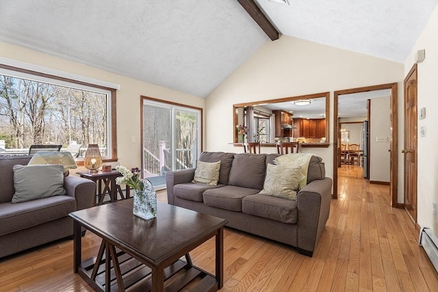 living area with beamed ceiling, light wood-type flooring, high vaulted ceiling, baseboard heating, and baseboards