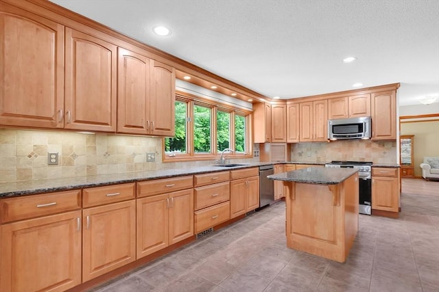 5 Evergreen Cir, Wilbraham, MA 01095 - kitchen with stainless steel appliances, a sink, dark stone counters, a kitchen island, and decorative backsplash