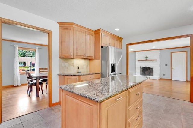 5 Evergreen Cir, Wilbraham, MA 01095 - kitchen featuring stainless steel refrigerator with ice dispenser, light tile patterned floors, a center island, light brown cabinetry, and light stone counters