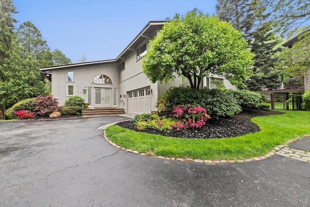 view of side of home with french doors, driveway, and an attached garage