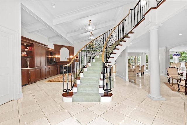 staircase featuring decorative columns, healthy amount of natural light, tile patterned flooring, beam ceiling, and coffered ceiling