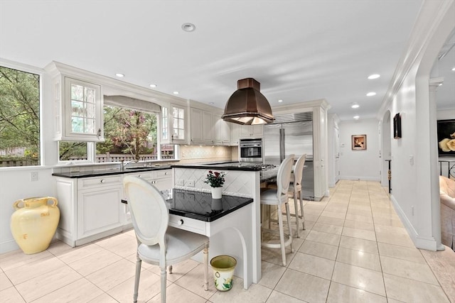 kitchen featuring stainless steel appliances, light tile patterned flooring, dark countertops, a kitchen island, and recessed lighting