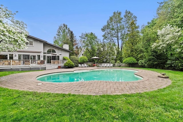 view of swimming pool with a wooden deck and a patio