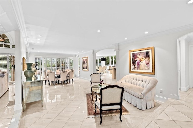 living room with ornate columns, arched walkways, baseboards, crown molding, and recessed lighting