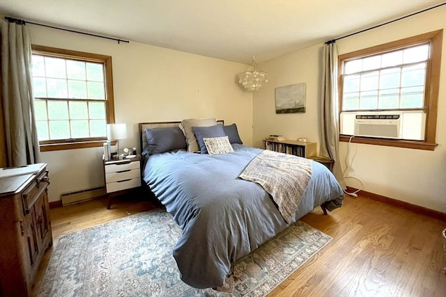 120 Tracy Cir, Amherst, MA 01002 - bedroom with wood finished floors, cooling unit, a chandelier, baseboards, and baseboard heating