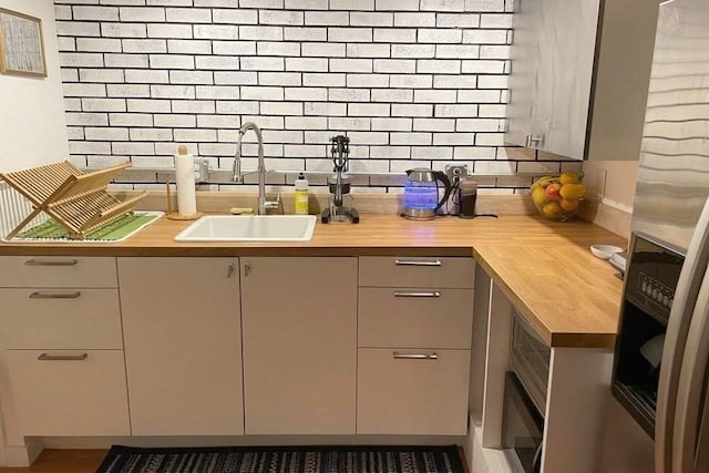 120 Tracy Cir, Amherst, MA 01002 - kitchen with butcher block counters, a sink, tasteful backsplash, and stainless steel refrigerator with ice dispenser