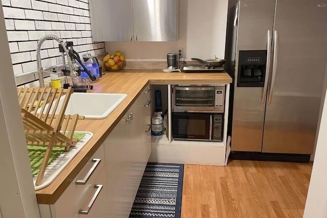 120 Tracy Cir, Amherst, MA 01002 - kitchen featuring stainless steel fridge with ice dispenser, wooden counters, light wood finished floors, black microwave, and a sink