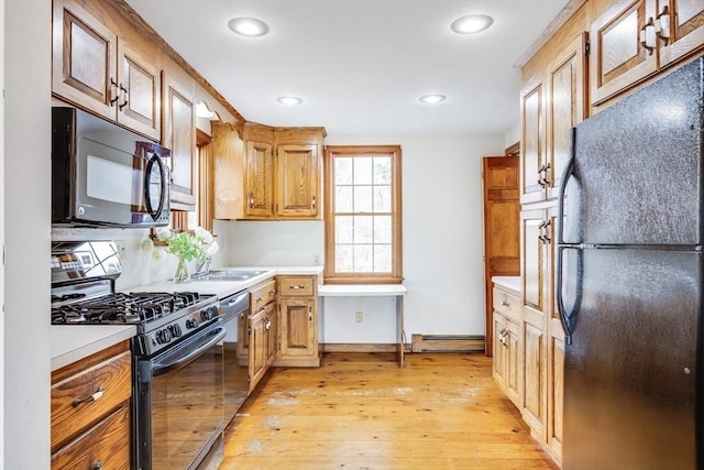 kitchen featuring black appliances and light hardwood / wood-style flooring