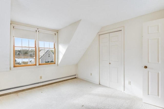 additional living space featuring light colored carpet, a baseboard heating unit, and vaulted ceiling