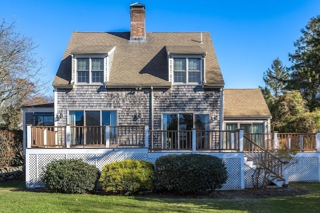 back of house featuring a wooden deck and a yard