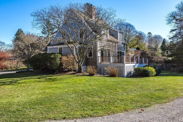 exterior space featuring a wooden deck and a lawn