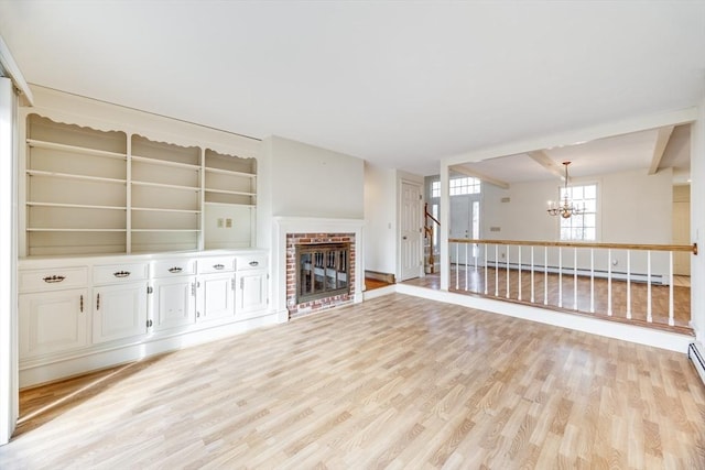 unfurnished living room featuring a baseboard radiator, light wood-type flooring, a notable chandelier, and a fireplace