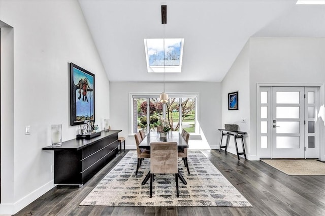 dining space with baseboards, dark wood-type flooring, a skylight, and high vaulted ceiling