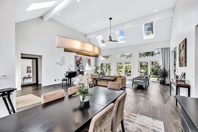 dining room featuring a skylight, plenty of natural light, wood finished floors, and beamed ceiling