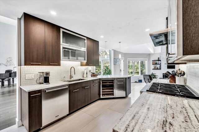 kitchen featuring dark brown cabinetry, beverage cooler, appliances with stainless steel finishes, and a sink