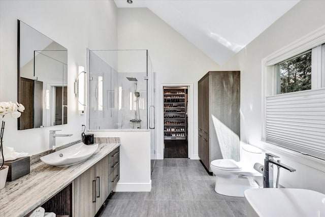 full bathroom featuring vanity, a soaking tub, vaulted ceiling, a walk in shower, and toilet