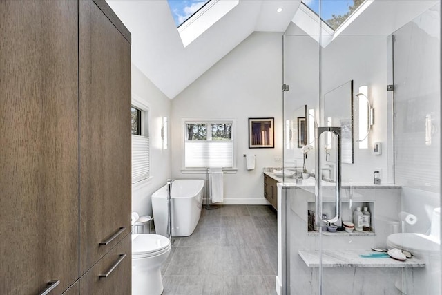 bathroom with vanity, a stall shower, a skylight, a freestanding tub, and high vaulted ceiling