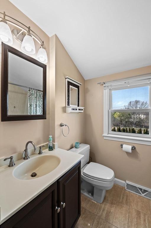 12 Jacobs Ave, Danvers, MA 01923 - full bath featuring vaulted ceiling, toilet, vanity, and baseboards