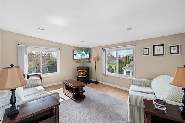 12 Jacobs Ave, Danvers, MA 01923 - living room featuring a wood stove, healthy amount of natural light, light wood-style floors, baseboards, and lofted ceiling