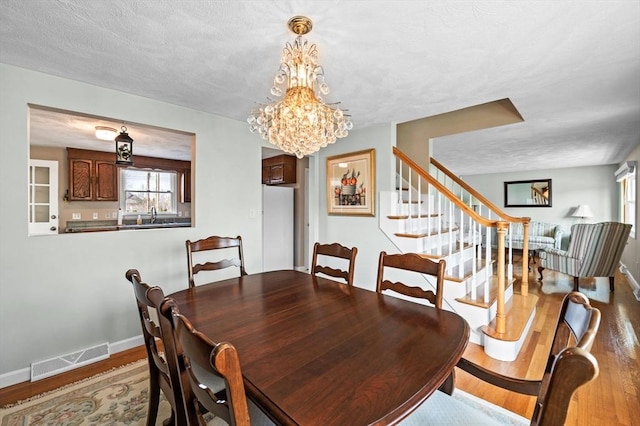 12 Jacobs Ave, Danvers, MA 01923 - dining area featuring wood finished floors, stairway, a chandelier, and baseboards
