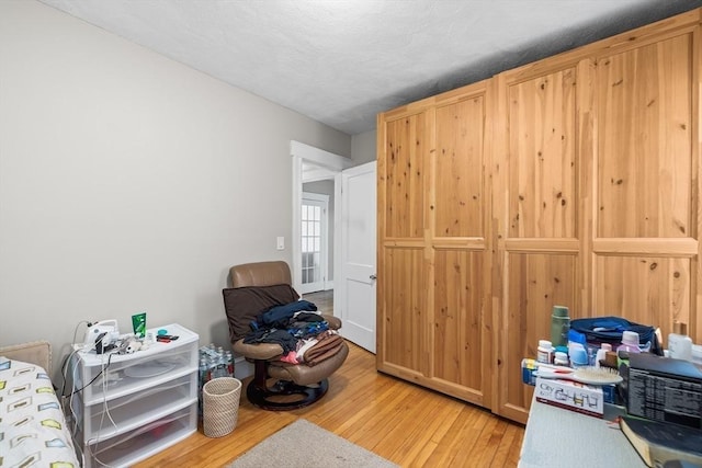 bedroom with light hardwood / wood-style floors and a textured ceiling