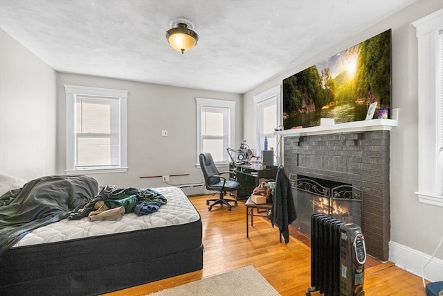 bedroom featuring hardwood / wood-style floors and a fireplace