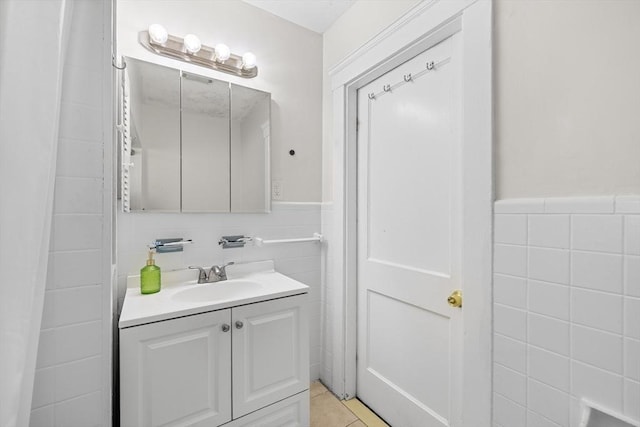 bathroom featuring tile patterned flooring, vanity, and tile walls