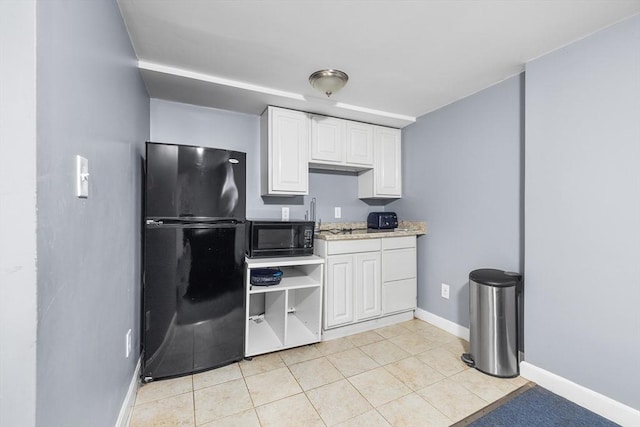 kitchen with light tile patterned floors, white cabinetry, and black appliances