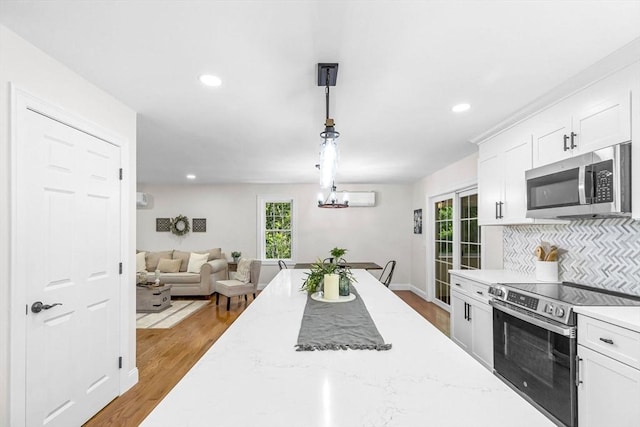 105 Forest Ave, Warren, MA 01585 - kitchen featuring appliances with stainless steel finishes, healthy amount of natural light, decorative backsplash, white cabinetry, and recessed lighting