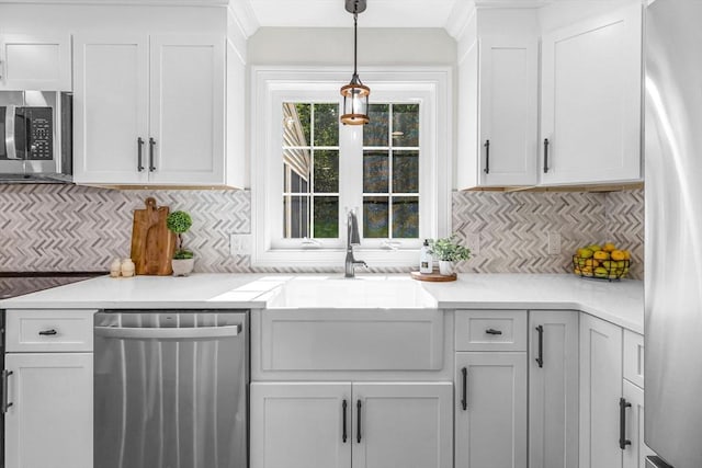 105 Forest Ave, Warren, MA 01585 - kitchen featuring stainless steel appliances, white cabinetry, decorative light fixtures, backsplash, and light countertops