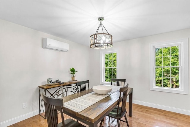 105 Forest Ave, Warren, MA 01585 - dining space featuring a wall unit AC, light wood-style flooring, and a chandelier